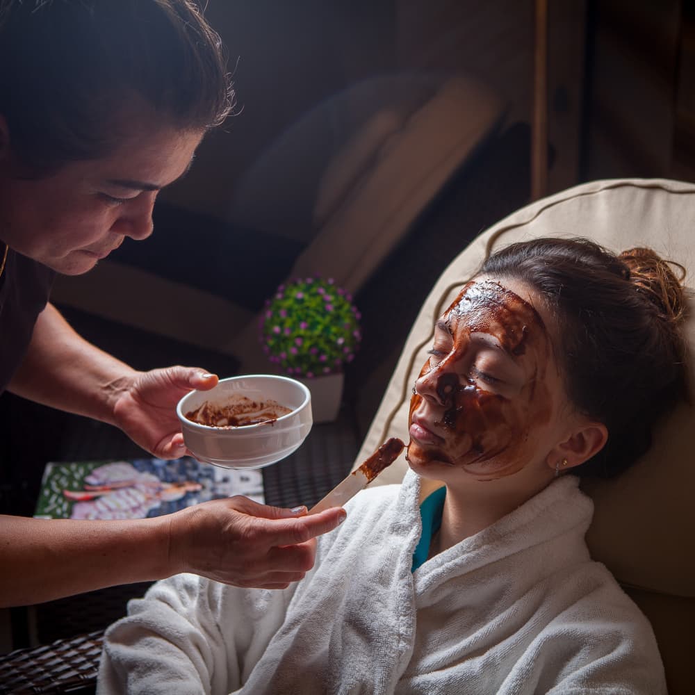 Practitioner performing a guided Ayurvedic skin therapy in a calming room.